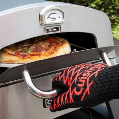 gloved hand pulling handle of pizza oven