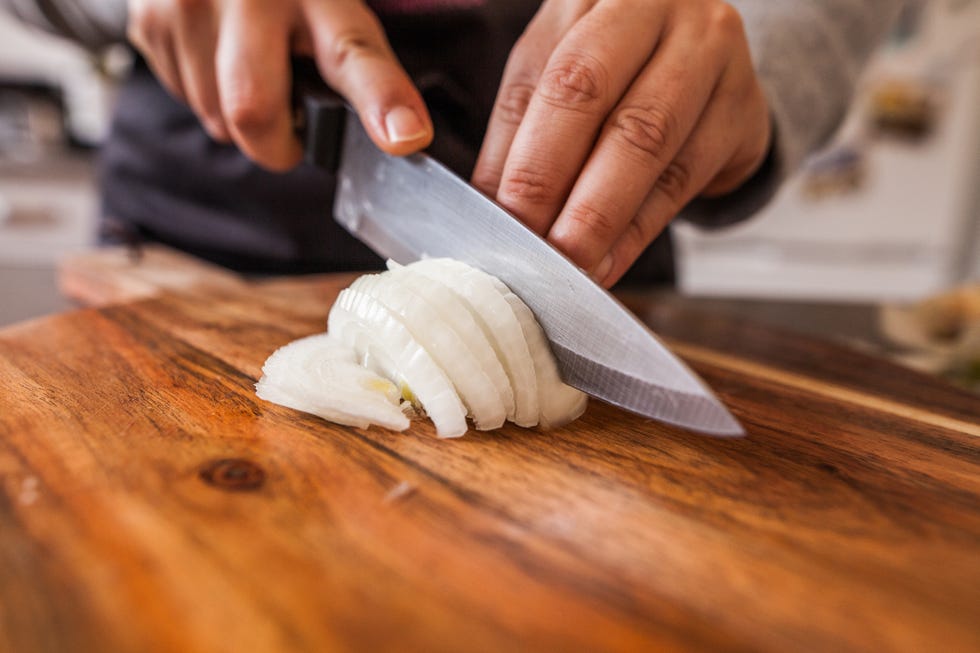 onions being sliced on a cutting board