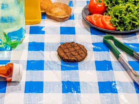 Burger placed on a petri dish on a picnic table setting