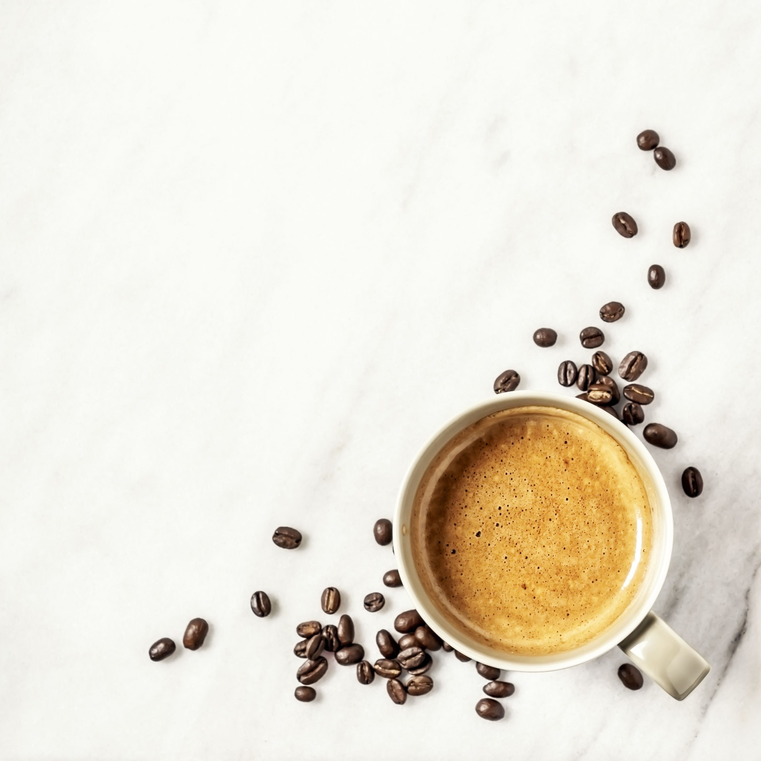 https://hips.hearstapps.com/hmg-prod/images/cup-of-coffee-and-coffee-beans-on-white-marble-royalty-free-image-1590505189.jpg