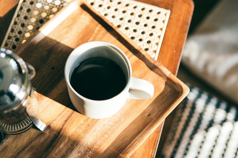 a cup of coffee on the serving tray under sunlight