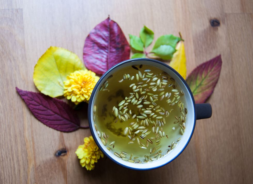 Cup of fennel tea with seeds. Autumnal decoration. Closup.