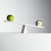 Cupcake tipping seesaw with green apple on opposite end