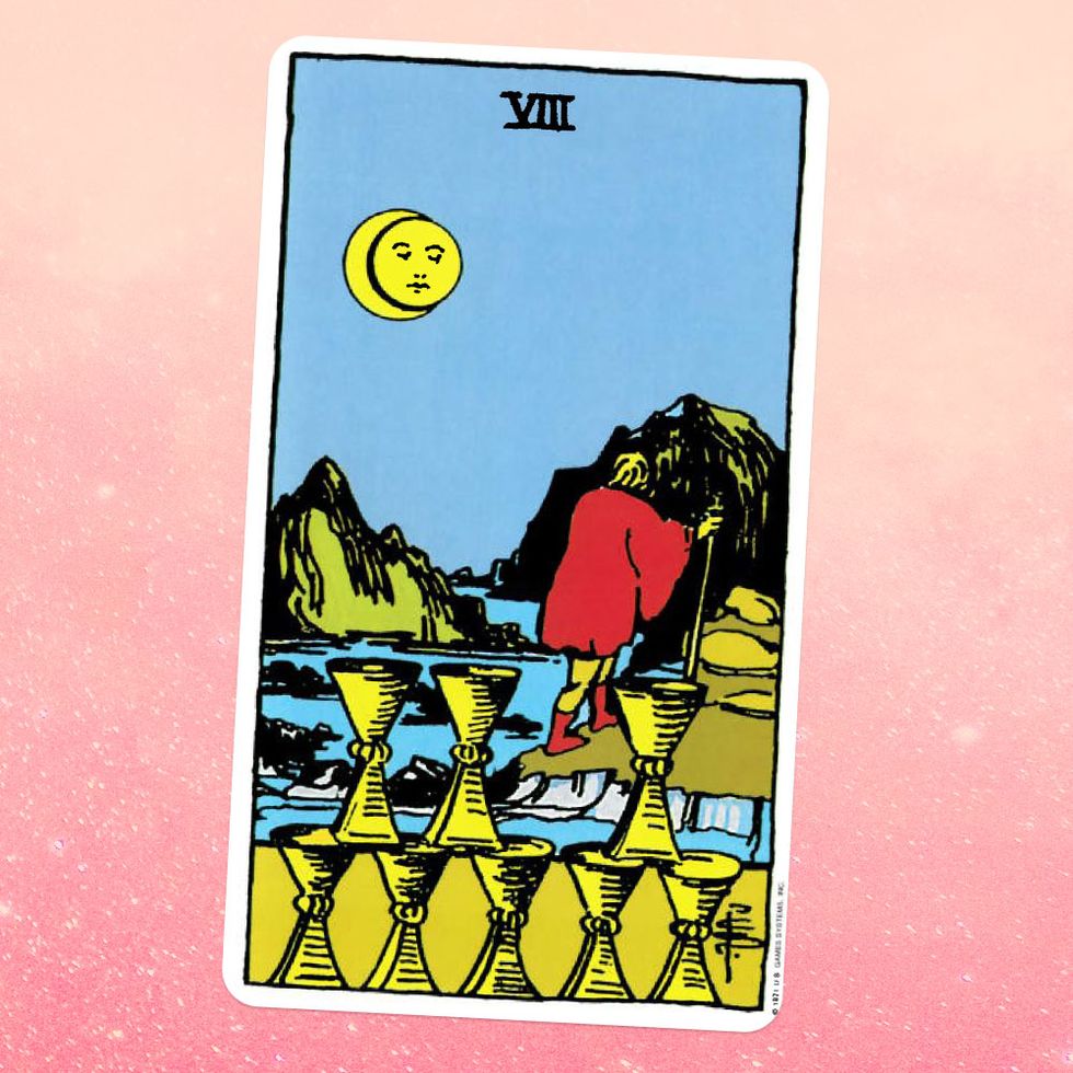the tarot card the eight of cups, showing a person walking on a hilly shorline, with eight golden cups below them