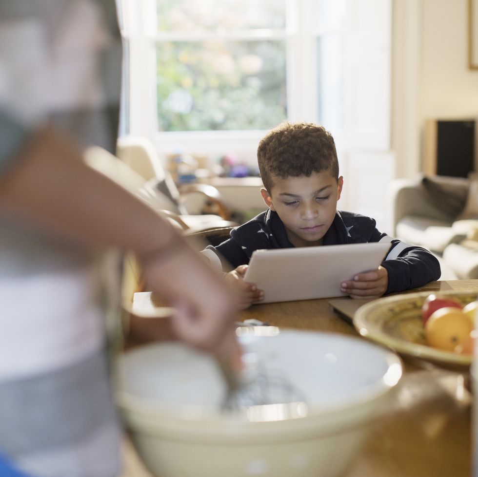 Curious boy using digital tablet in kitchen