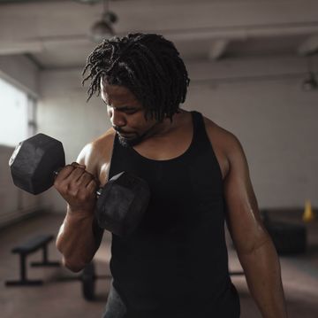 handsome african american man working out with dumbbells in the gym