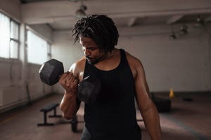 handsome african american man working out with dumbbells in the gym