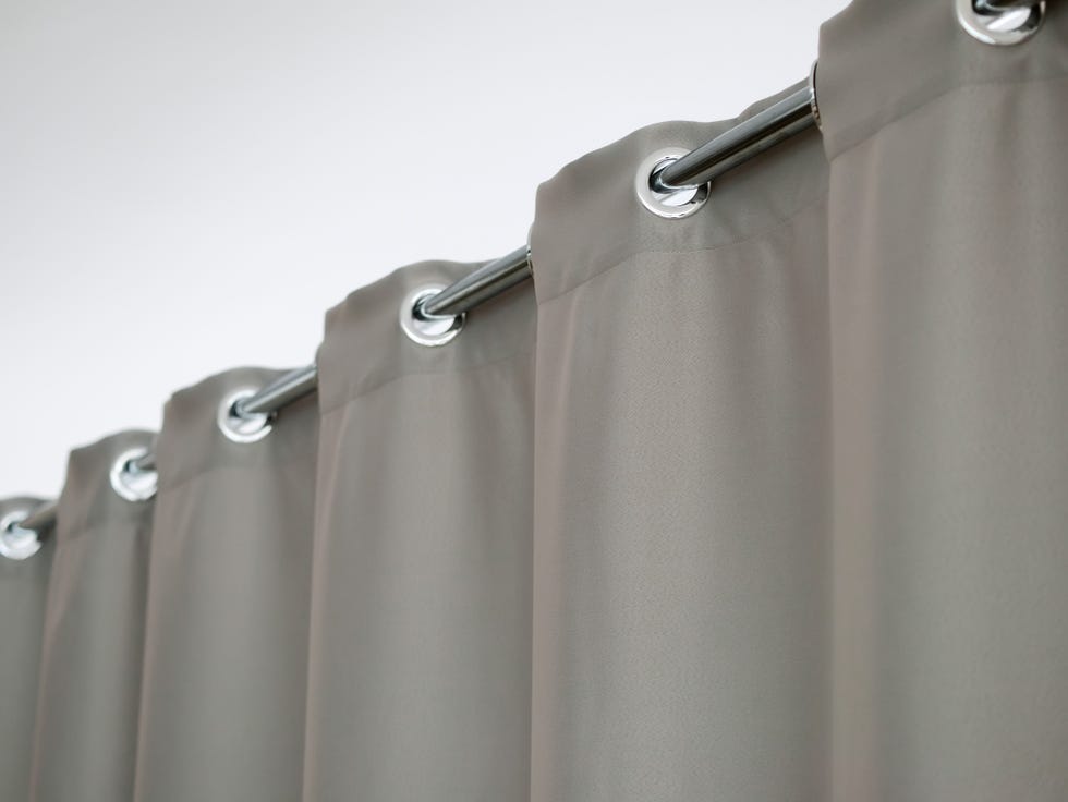heavy thick gray curtain with grommets on the stainless tube of the cornice
