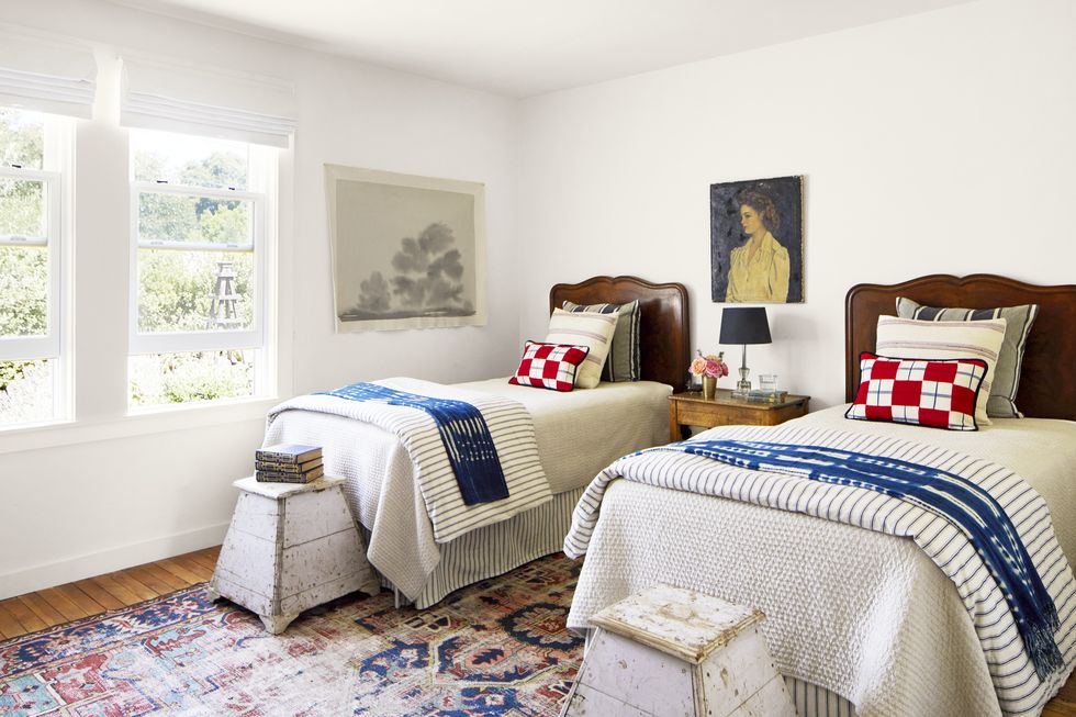 bedroom with wood headboard twin beds and vintage blue, white, and red linens