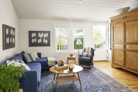 white shiplap living room with blue sectional and pine armoire