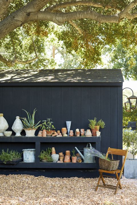 black garden shed with builtin potting bench