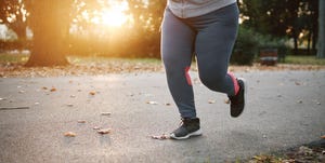Curvaceous young female runner running in park, waist down