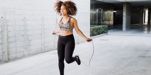 Curvy African American Woman Skipping Rope In Urban Area