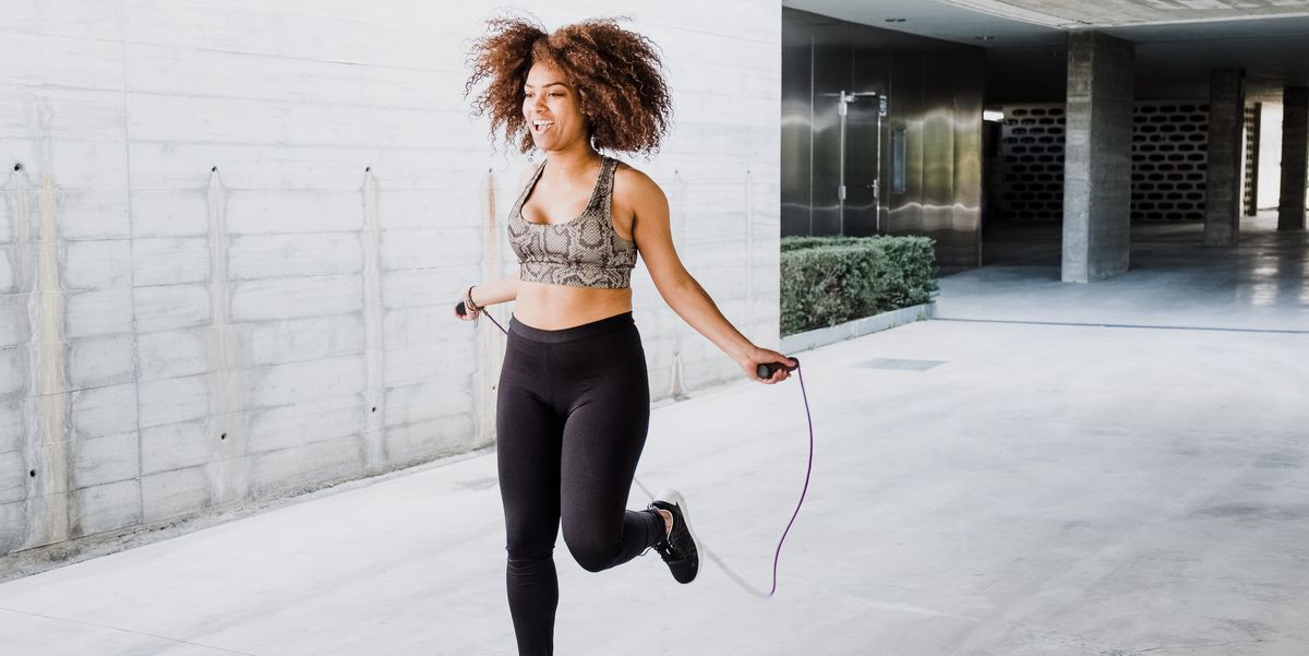 curvy african american woman skipping rope in urban area