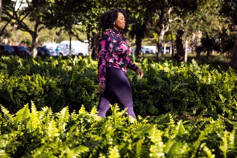 curvy young black woman walking, jogging and running in the city public park