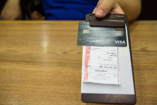 customer handed the credit card on bill paper, in leather black bill reciept