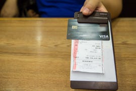 customer handed the credit card on bill paper, in leather black bill reciept