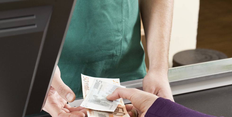 a customer handing a cashier cash at the supermarket