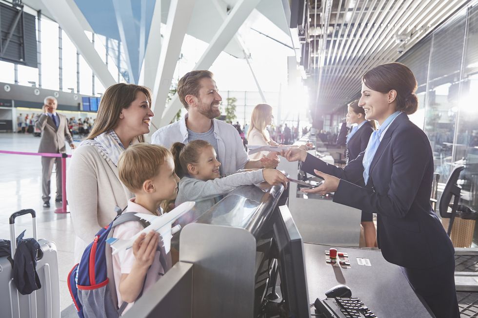customer service representative checking family tickets at airport check in counter