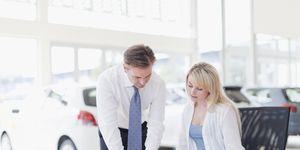customer signing at car dealership
