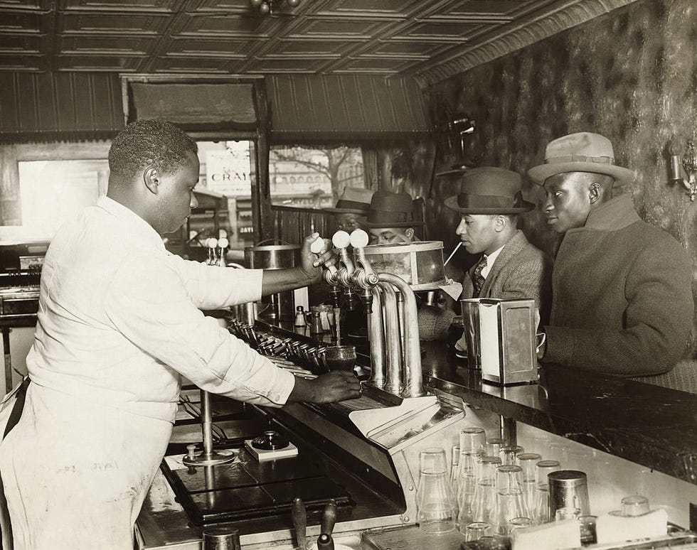 african american men sitting at soda fountain