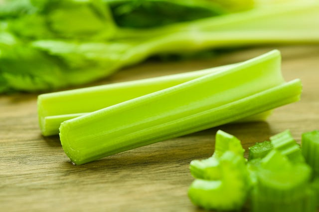 Cut celery sticks and leaves on wooden table