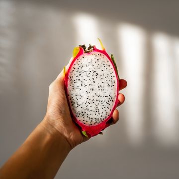 cut dragon fruit in hand on a white background on a sunny day.