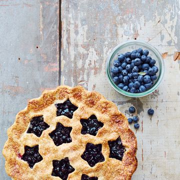 blueberry pie with cutout stars on a wooden table