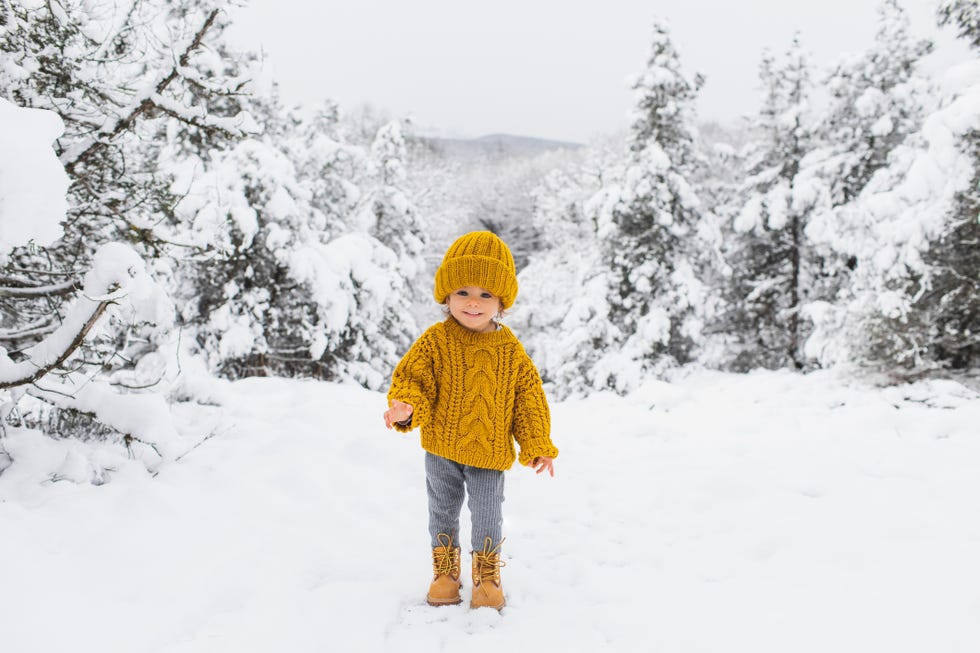 niña en la nieve con gorro y jersey