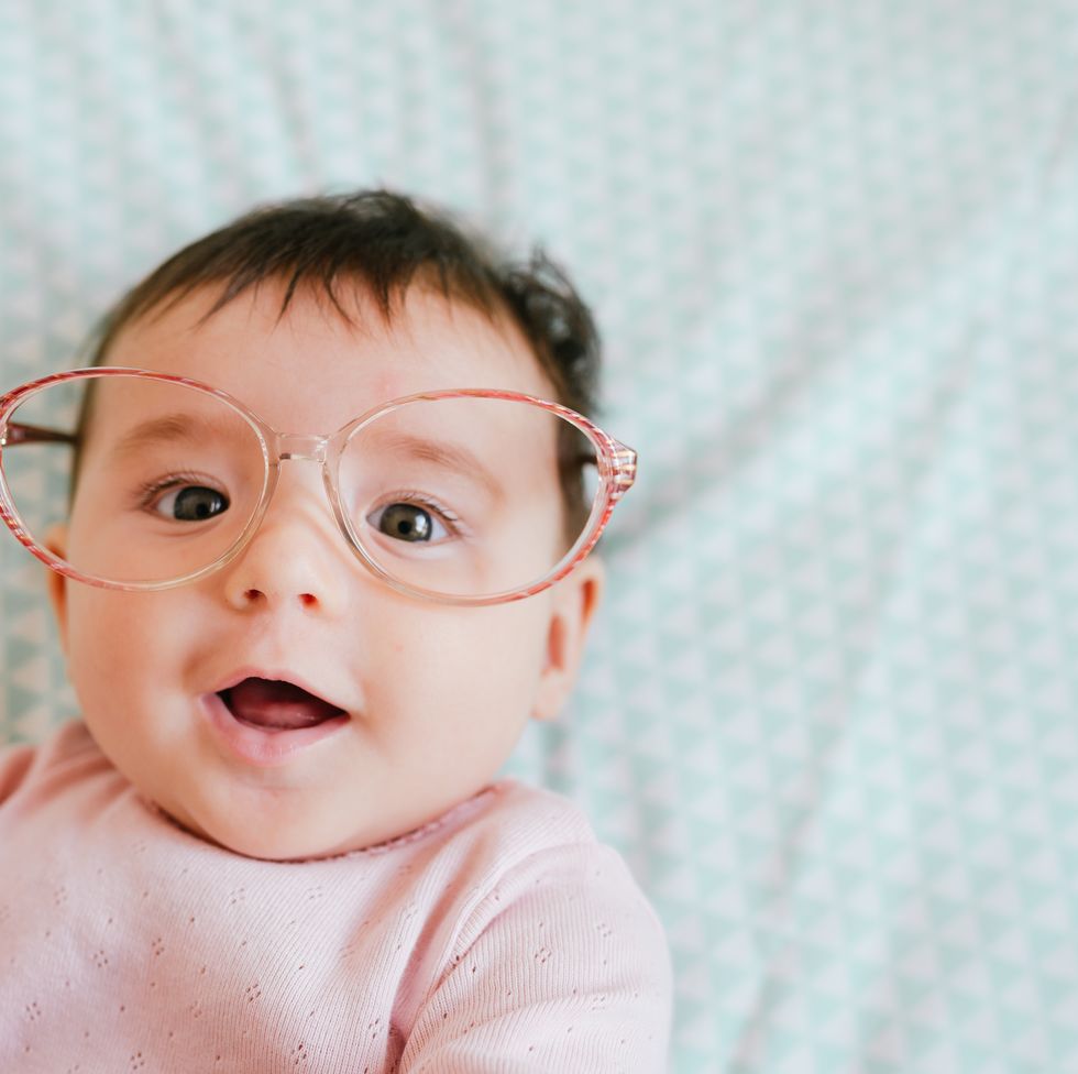 cute baby girl with woman glasses making funny faces