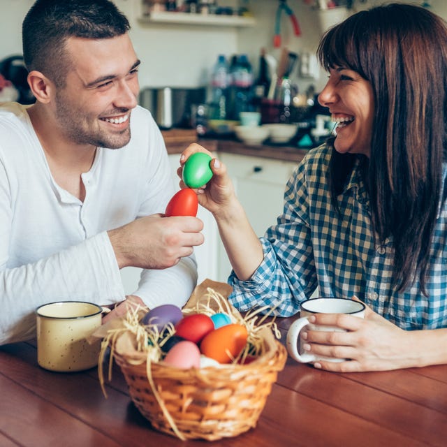 young couple breaking easter eggs