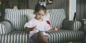cute girl playing with fidget spinner in living room at home