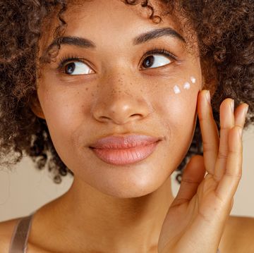 woman applying dots of skincare to face