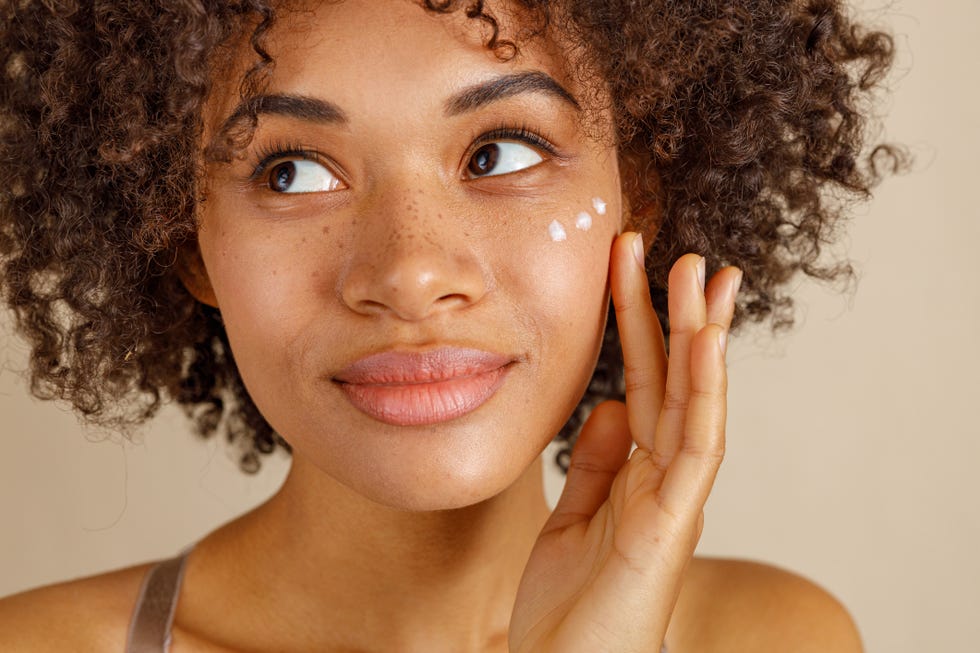 cute lady using cosmetic product in studio