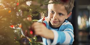 Cute little boy decorating christmas tree