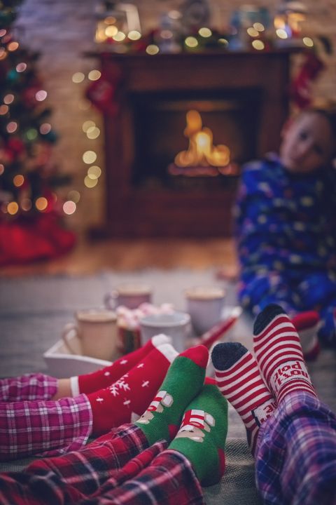 cute little kids in pyjamas and christmas socks drinking hot chocolate with marshmallows for christmas