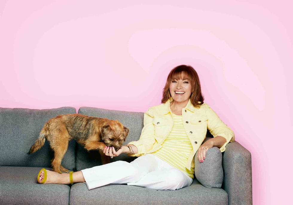 tv presenter lorraine kelly sitting on sofa with her border terrier dog angus
