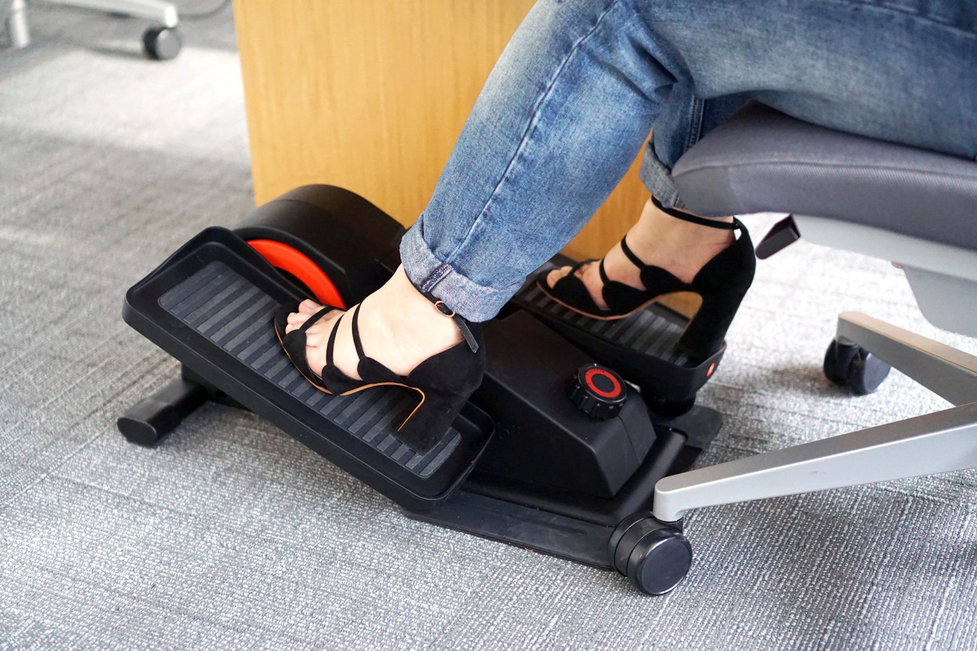 person wearing jeans and heels using cuubi under desk elliptical