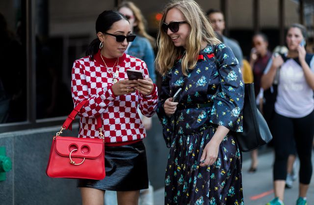 Twee vrouwen op straat kijken op een smartphone