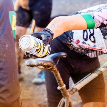 cyclist handing off beer at cyclocross event