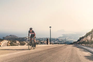 Cyclist climbing up Cumbre Del Sol, Benitachell, Spain