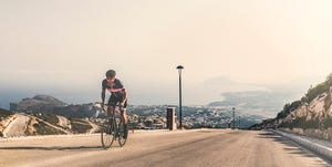 Cyclist climbing up Cumbre Del Sol, Benitachell, Spain