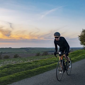 cyclist on a country road at sunset