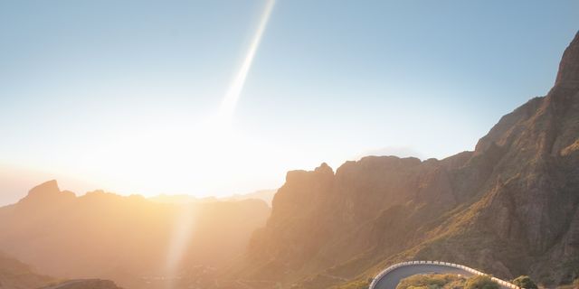 cyclist on beautiful road in mountains at sunset