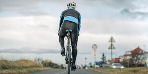 cyclist riding his bike on empty road, does cycling build glutes