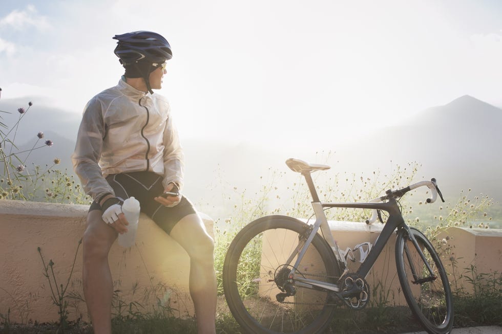 Cyclist taking break, sitting near bike