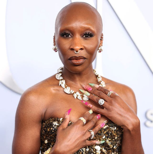 Cynthia Erivo in June 2024 cynthia erivo wears a gold sequin dress, rests her hands against her chest and looks at the camera
