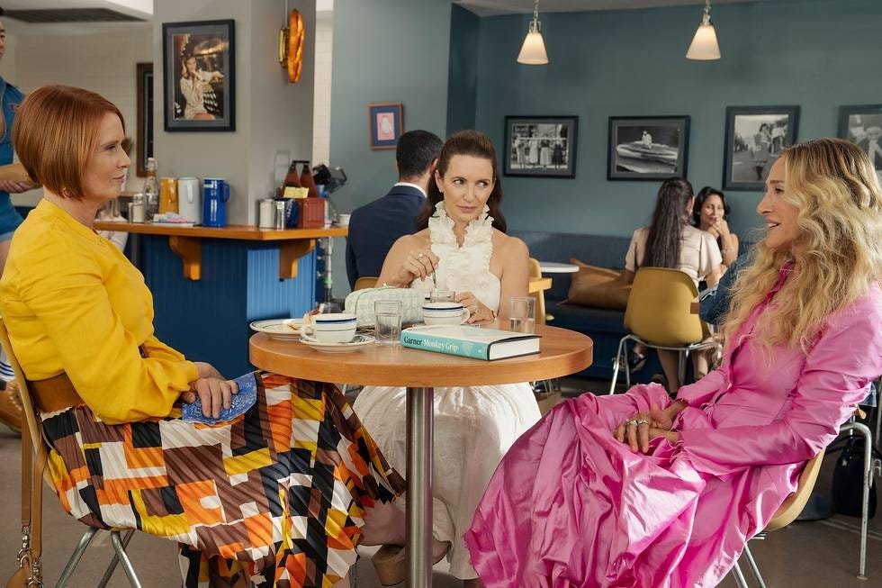 three women engaged in conversation at a café table