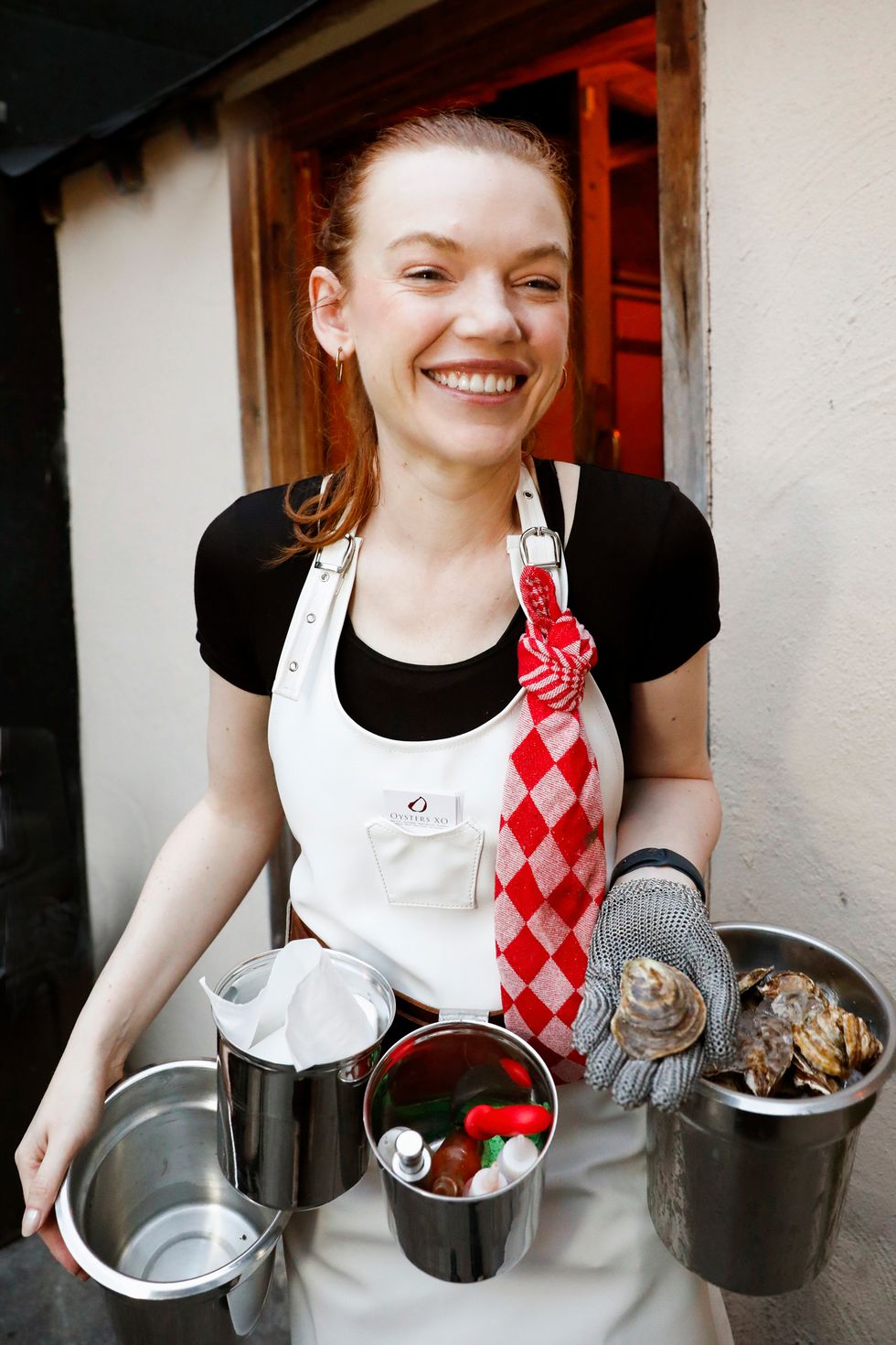 a woman smiling and holding an oyster