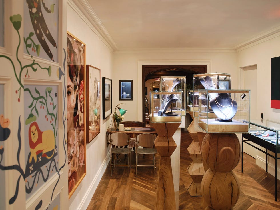 Jewelry display in a gallery with art pieces on the walls.